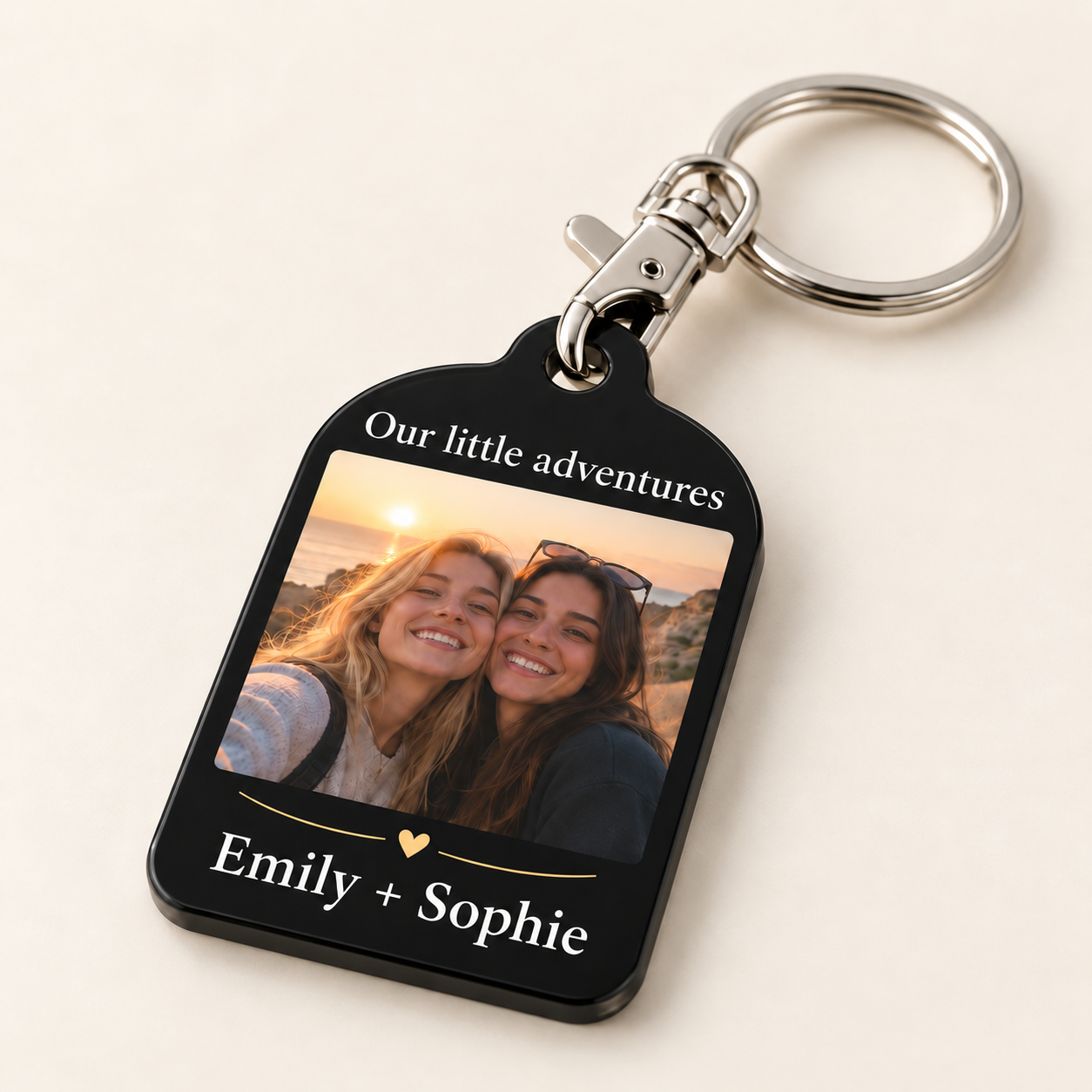 Angled close view of the Emily + Sophie photo keyring, with a slim black acrylic edge, flat front printing and a silver-colour lobster clasp hooked through the acrylic hole.